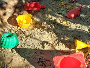 Bunte Schaufeln und Förmchen im Sandkasten